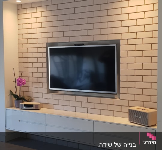 ארונית עץ לבנה מתחת לטלוויזיה על קיר לבנים